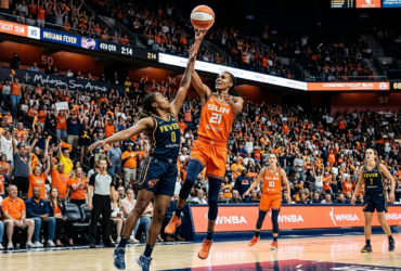 Indiana Fever and Connecticut Sun players competing during an exciting WNBA game with a packed arena crowd