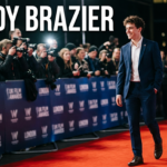 Freddy Brazier attending a public event, smiling on the red carpet in a modern suit during a UK entertainment appearance.
