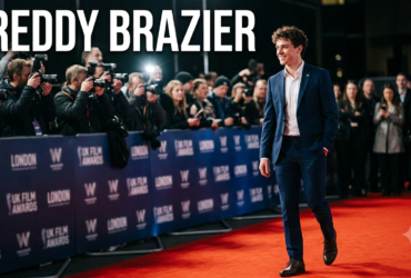 Freddy Brazier attending a public event, smiling on the red carpet in a modern suit during a UK entertainment appearance.